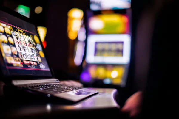 A woman smiling by bright slot machines showing lucky symbols, showcasing the exciting slot offerings at CHEZA GAME.